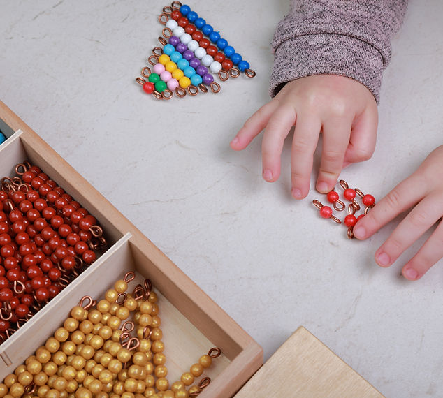 Child working with Montessori bead materials practicing practical life skills at Little Tree NYC