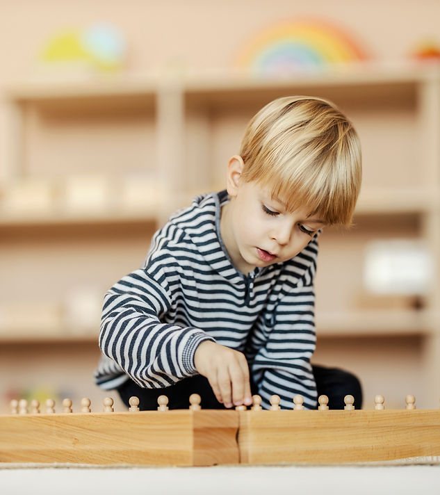 Toddler working with Montessori wooden peg materials at Little Tree NYC classroom